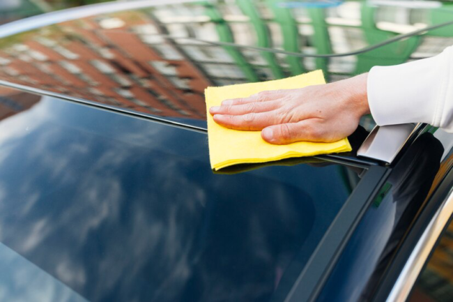 close-up-person-cleaning-car-exterior_23-2148194115